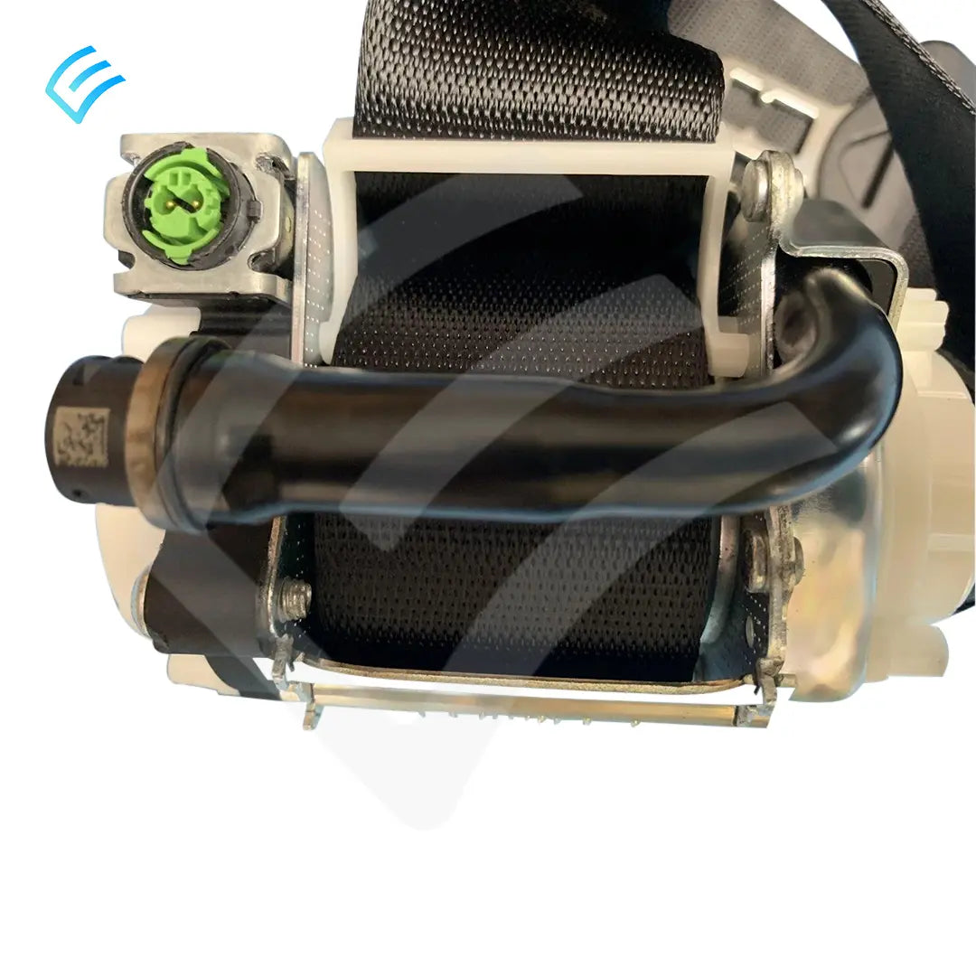 Seat belt retractor mechanism close-up showing metal housing, belt spool and green electrical connector