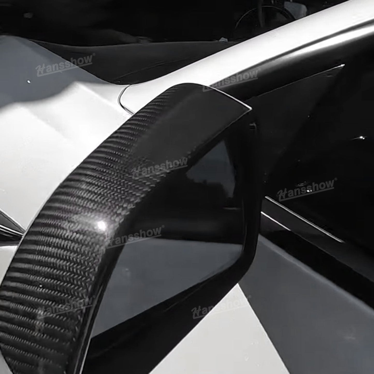 Side mirror cover shown from rear angle on white Tesla, highlighting curved edge and taper