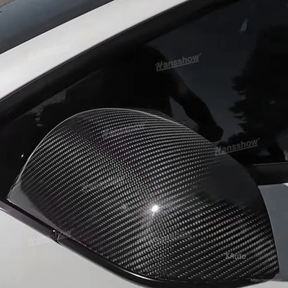 Extreme close-up of carbon fiber weave on installed mirror cap with glossy highlight
