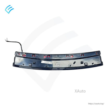 Rear view of trunk garnish trim showing wiring lead, mounting points, and factory part label on backside