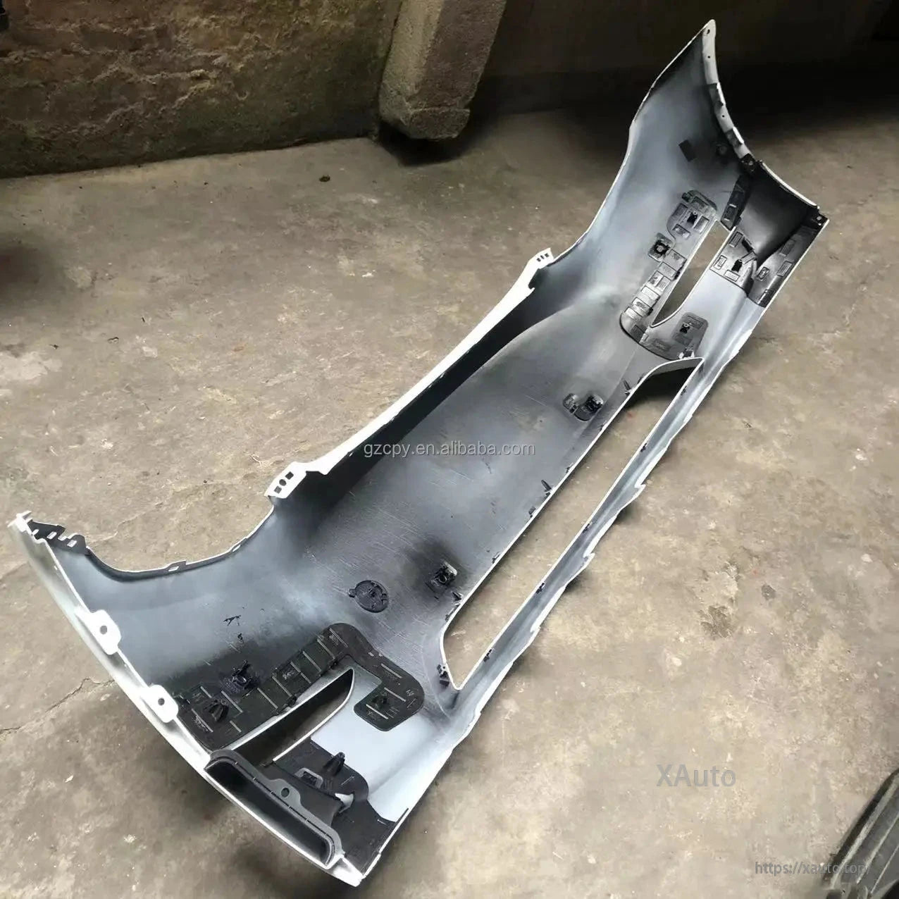 Angled interior view of front bumper cover showing lower grille opening and molded mounting features