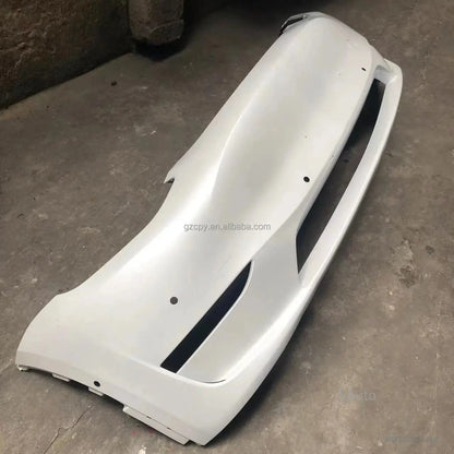 Primed white bumper cover angled view showing center opening and side intake cutouts
