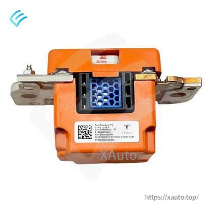 Close-up rear label area on orange pyrotechnic disconnect showing Tesla part-number sticker and mounting tabs